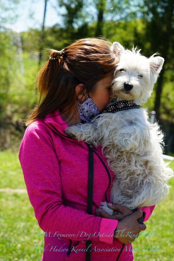 Woman holding her dog posing for the dogs outside the ring photography book 
