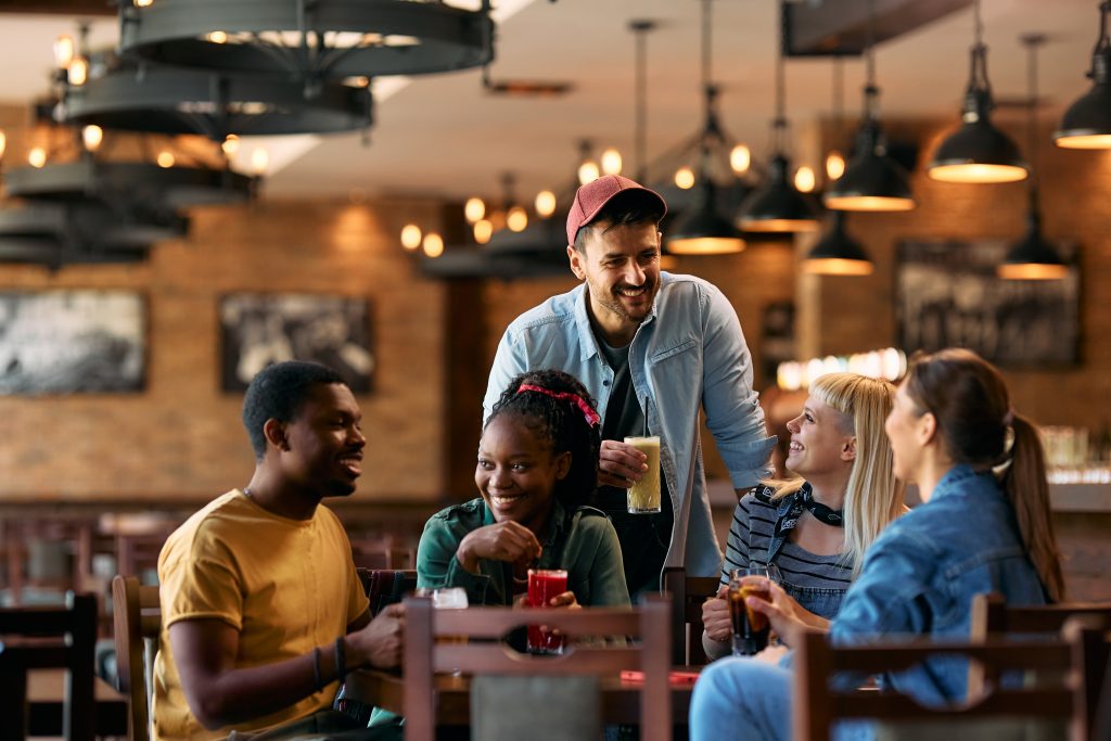 people at restaurant eating and laughing and drinking and having a good time