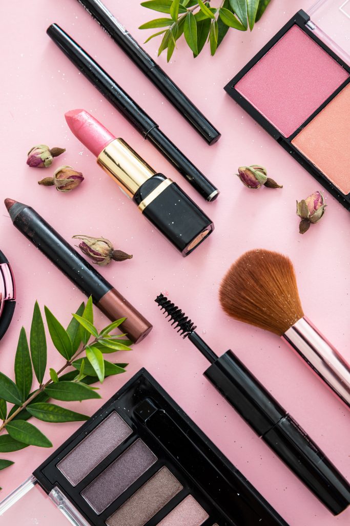 makeup products on pink table